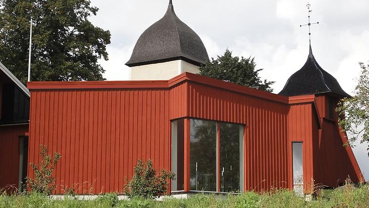 Ett församlingshus i rött trä och plåt.