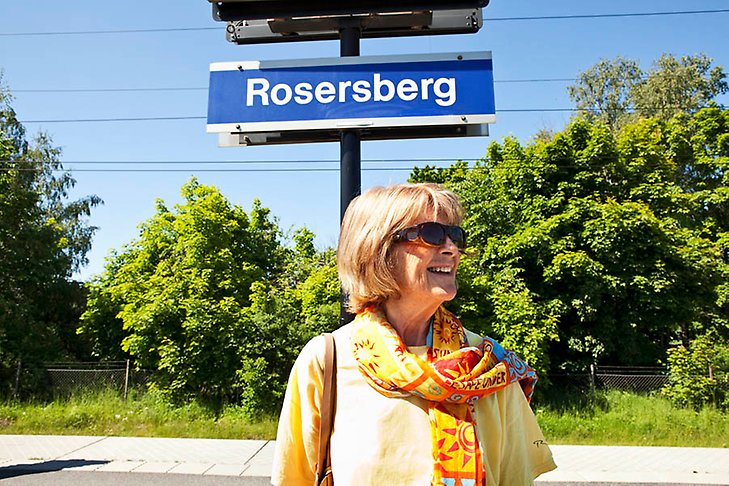 En kvinna står under en skylt som det står Rosersberg på.