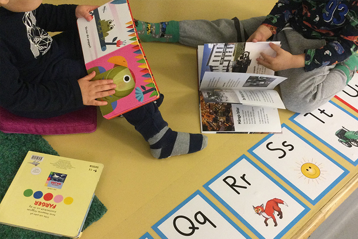 Barnen läser ur böcker och tittar på bokstäver. Foto: Sigtuna kommun