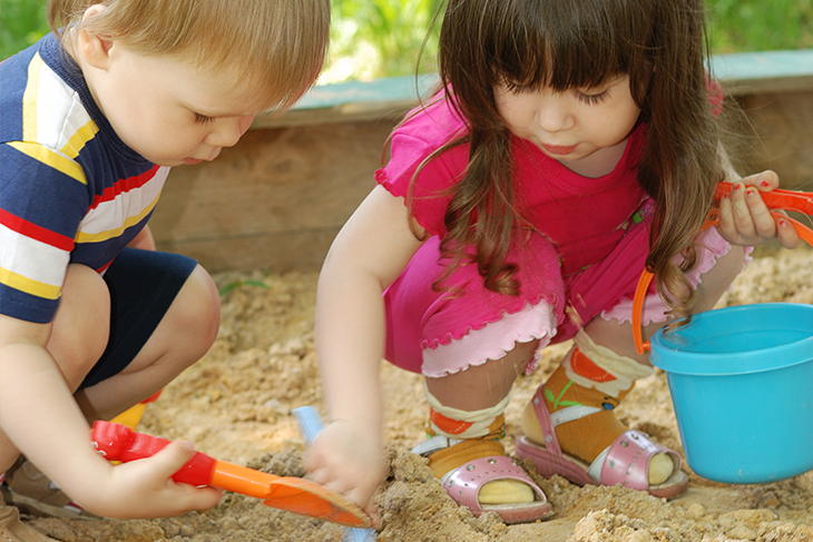 Två barn gräver i sandlådan. Fotograf: Mostphotos