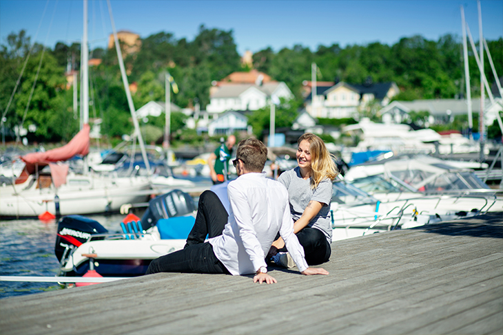 Två personer sitter på bryggan vid Sigtuna gästhamn. Fotograf: Rosie Alm (sam8, sam6)