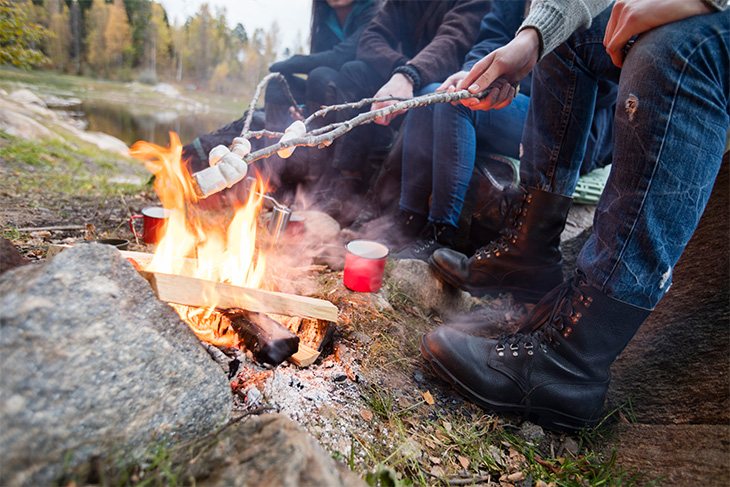Vänner grillar marshmallows över öppen eld. Foto: Mostphotos