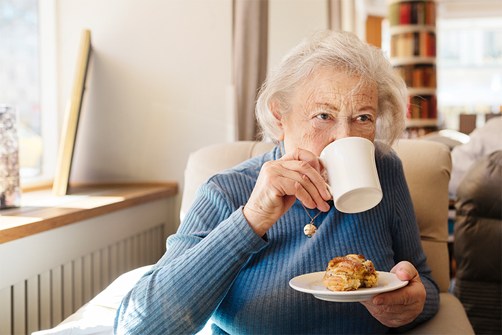 Pensionär fikar kaffe och bulle. Fotograf: Rebecka Rynefelt/Johnér