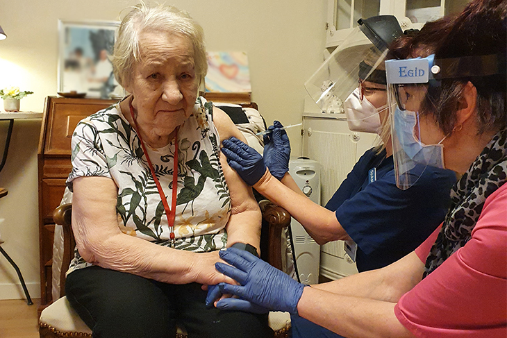 En dam vaccineras och får en spruta i armen