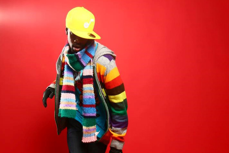 Isse Omari poserar ett danssteg i färgglada kläder 
