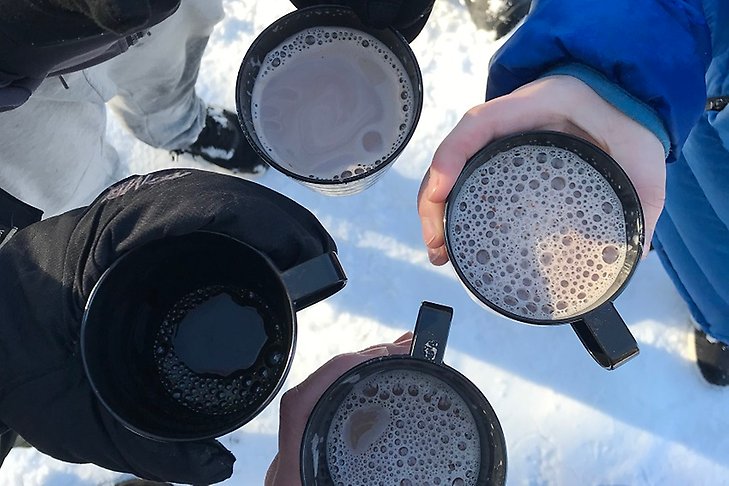 Fyra koppar varm choklad ute i snön.
