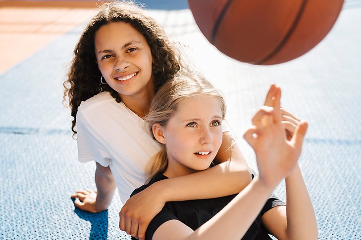 Två tjejer med basketboll.