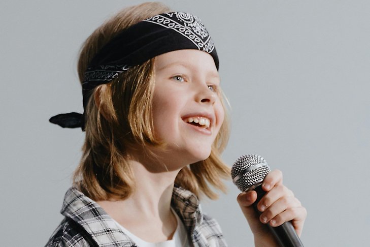Ett barn sjunger i en mikrofon.