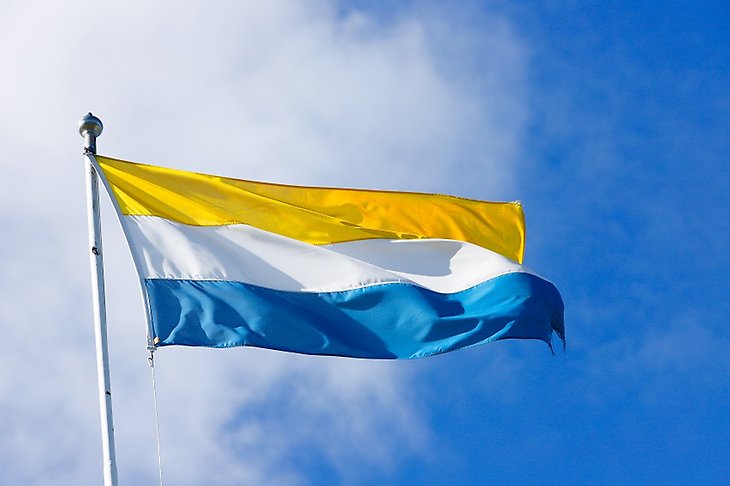 Tornedalens flagga med en blå, vit och gul rand.