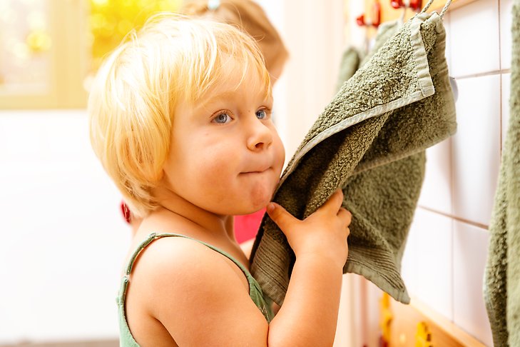 Förskolebarn torkar av sig på en handduk