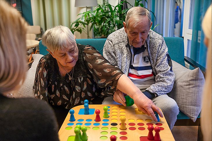 Två äldre personer spelar sällskapsspel