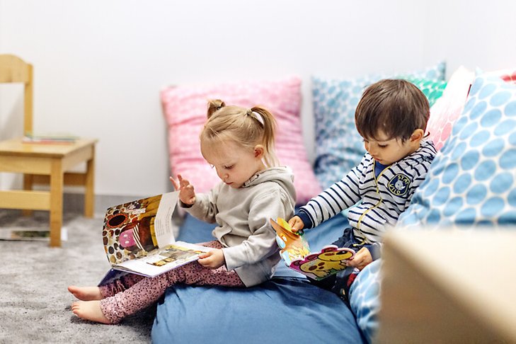 Två barn läser böcker. Fotograf: Rosie Alm