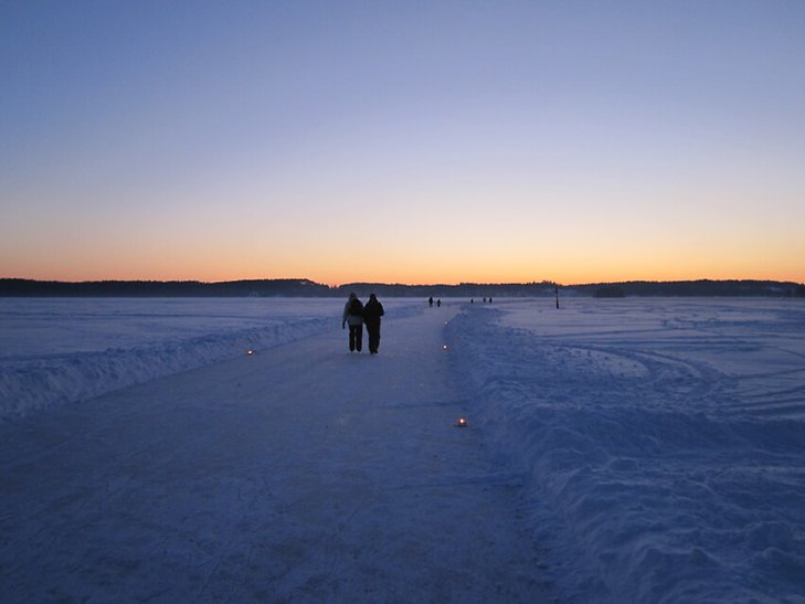 Personer åker skridskor på en plogad bana på isen på Mälaren.