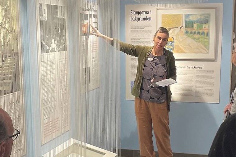 En museiintendent ger guidad visning av utställningen Mottagandet på Sigtuna museum