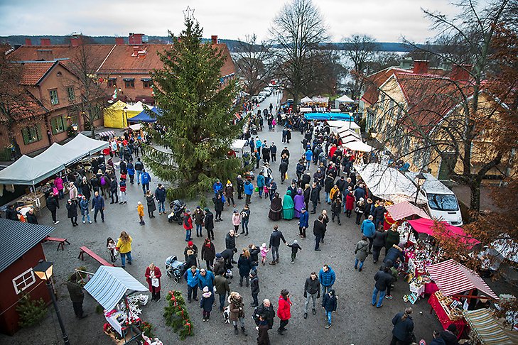 Bild uppifrån visar marknadsstånd och människor som julhandlar på torget i Sigtuna. 
