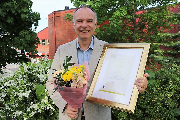 Greger Fellin med diplom och blommor.