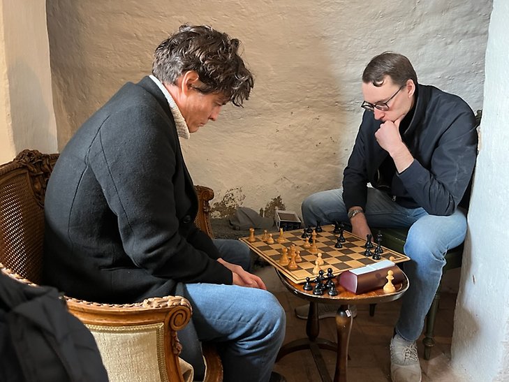 Två män som sitter vid ett bord och spelar schack